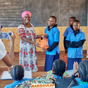 Al Saïda Osei presenting young star with gift during Humanitarian visit at Bilingual school in Bangoulap, West Cameroon PHOTO COURTESY OF ASPROBIR